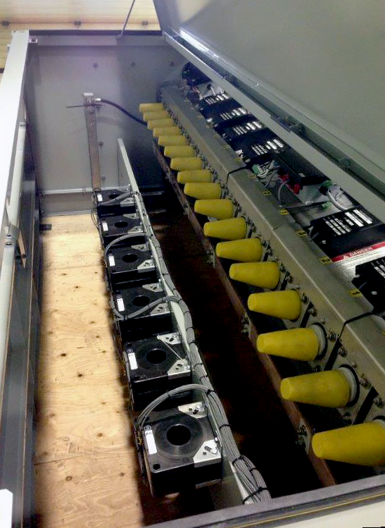 The inside of a Remote-Supervisory Vista&reg; Underground Distribution Switchgear unit. The unit's top is open. On the right, bushings are covered with yellow caps. Below and to the left, six ways lie on the "floor" level.