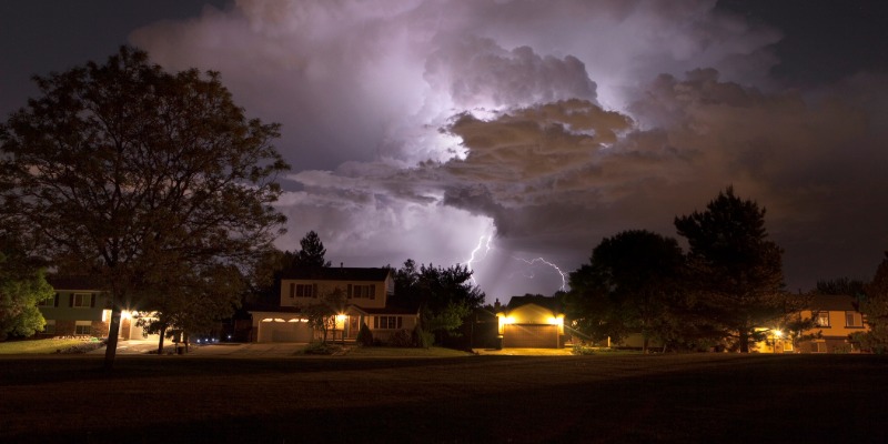 stormy skies and lightning strikes above a neighborhood